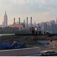 A wide shot of real estate experts evaluating a site, with the skyline in the background